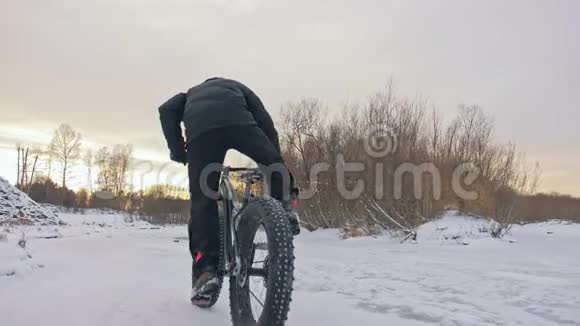 杂技表演骑自行车时站在自行车座位上职业极限运动运动员骑着胖自行车视频的预览图
