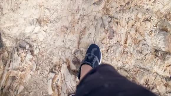 4kPOV视频男性脚穿运动鞋走下悬崖一个人在陡峭的山岩上视频的预览图