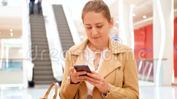在商场自动扶梯旁坐在长凳上给她输入信息的4k段画面视频的预览图