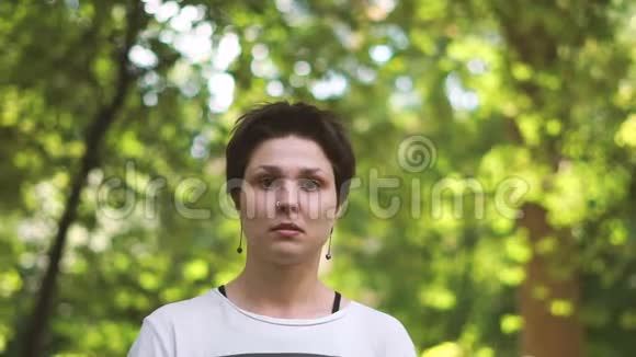 忧郁的黑发女人站在懒洋洋的树林里点头视频的预览图