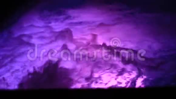 彩色水间歇泉水的蓝色和紫色照明浪漫的夜晚视频的预览图