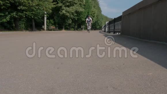 男性骑自行车的人经过相机从一个较低的角度移动到相机视频的预览图