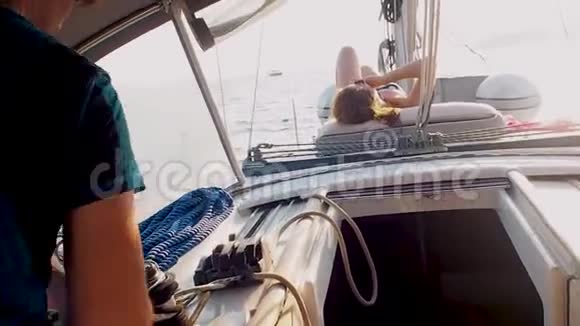 乘游艇航行在帆下男游艇司机在绞车上系绳视频的预览图