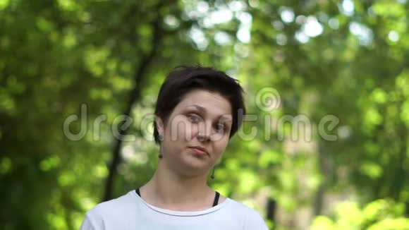 活泼的深色头发的女人站着自信地摇着头站在邋遢的树林里视频的预览图