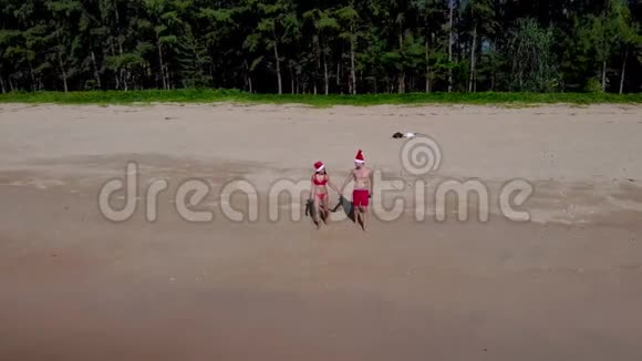 泰国KhaoLak海滩上的无人机带着夫妇和圣诞帽新年快乐视频的预览图