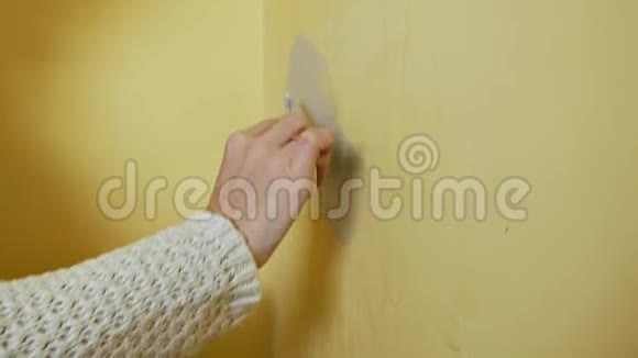 女孩在画之前把房间里的黄墙吐出来DIY修理把关节绑起来年轻女子穿上视频的预览图