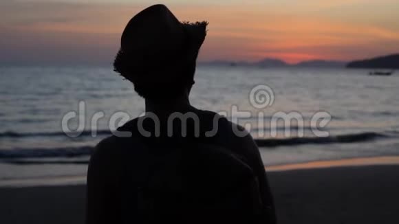 一个年轻的男性旅行体贴而平静的背包客望着大海想着旅途视频的预览图