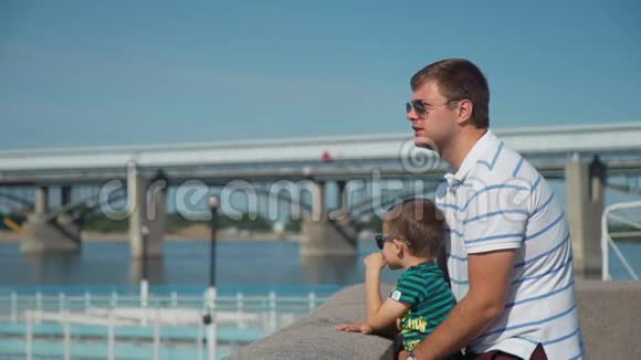 父亲和儿子在堤岸护墙附近视频的预览图