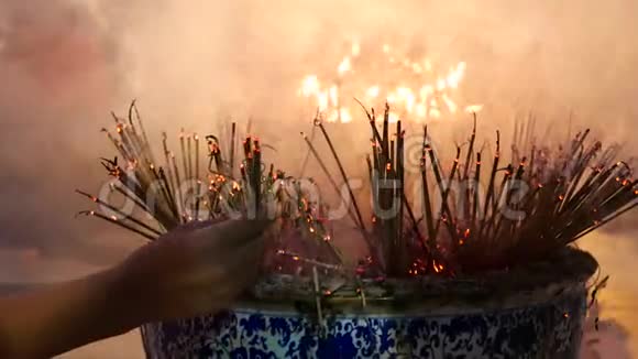 传统的火焰点燃香棒在佛教寺庙中祈祷火焰蜡烛用烟香棒燃烧温暖的光视频的预览图