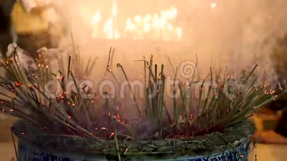 传统的火焰点燃香棒在佛教寺庙中祈祷火焰蜡烛用烟香棒燃烧温暖的光视频的预览图
