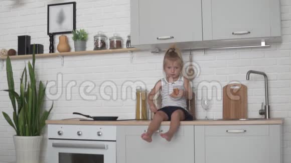 小女孩在厨房里吃面包视频的预览图