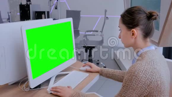 女人看着白色显示器的桌面电脑空白绿色显示视频的预览图
