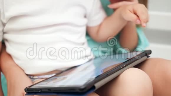 在玩教育电子游戏时使用平板触摸屏特写4k幼儿手指视频视频的预览图