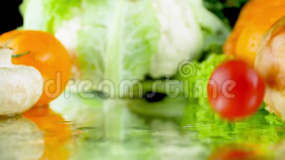 特写慢动作视频红色西红柿落在湿桌子上与新鲜蔬菜对抗健康营养概念视频的预览图