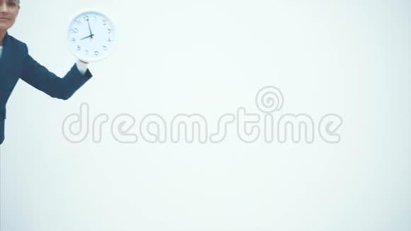一位年轻的老师出现在白色背景上上面有一个钟在这期间它表现出一种困倦的表情特写视频的预览图