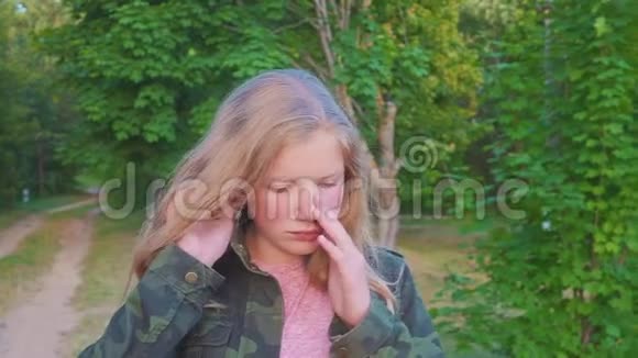 一张漂亮的十几岁悲伤女孩看镜头的特写肖像一头自然的金发一个幸福的微笑的白人孩子视频的预览图