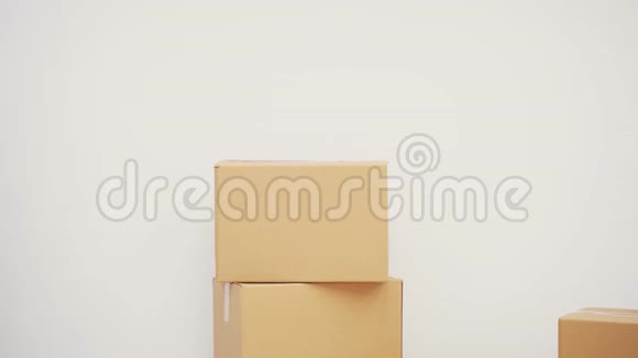 年轻人站在他的新公寓里靠在一堆纸箱上微笑着指着复印空间视频的预览图