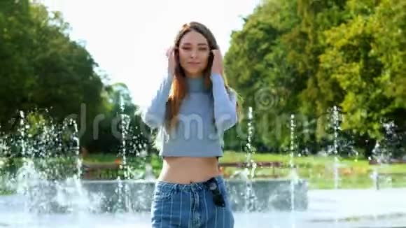 一幅欢快美丽的红发女子在公园看镜头的肖像背景是喷泉视频的预览图