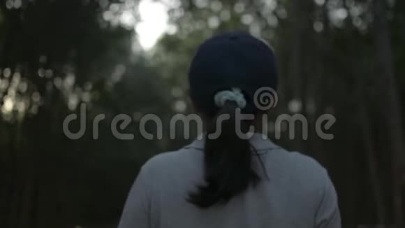 年轻漂亮的女人戴着帽子在普吉岛的红树林中穿过一条小径后视图跟随射击视频的预览图