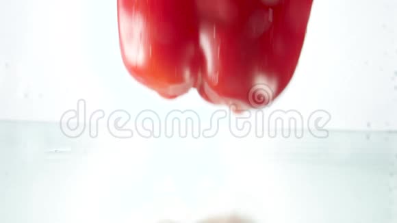 特写慢动作视频新鲜的红椒落在水里溅起水珠视频的预览图