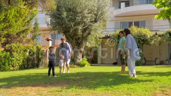 幸福的一家人在豪宅别墅前院慢动作跳跃暑假概念暑假期间视频的预览图