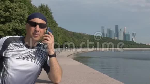 穿着运动服头戴头巾的中年男子在智能手机上讲话视频的预览图