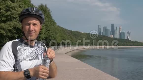 穿运动制服的人自行车头盔从塑料瓶里喝水视频的预览图