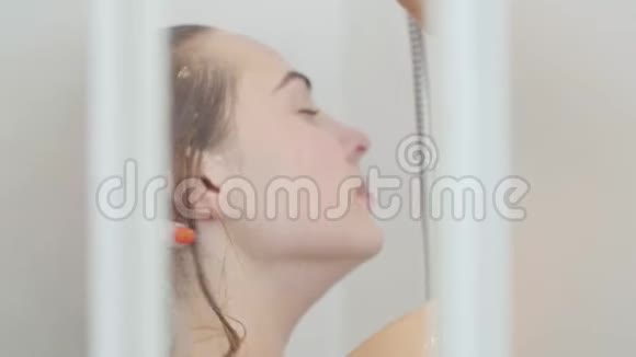 可爱的白种人女人在家或酒店洗澡美丽的女孩洗衣服在淋浴下尽情享受视频的预览图