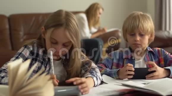 可爱的小男孩和女孩在家学习的前景检查答案在互联网上使用手机儿童视频的预览图