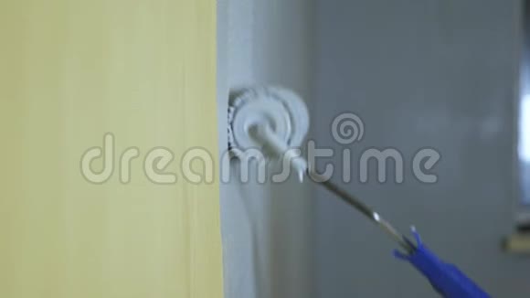 施工滚筒用灰色油漆粉刷黄色墙面视频的预览图