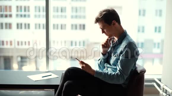 忧郁的年轻商人坐在椅子上使用平板电脑的画像视频的预览图