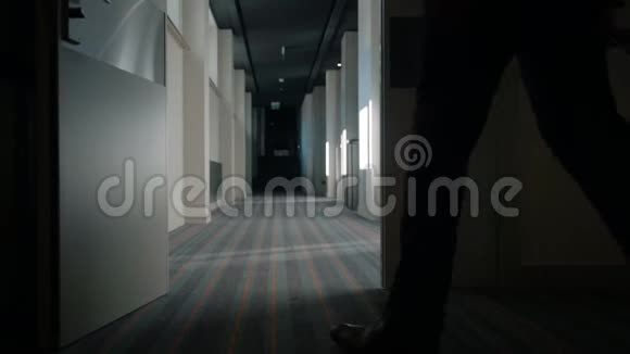 带旅行箱的商人在酒店走廊散步男士抵达酒店视频的预览图