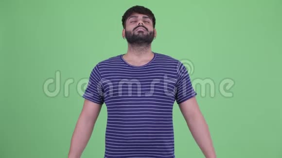 快乐年轻体重超重留胡子的印度男人闭着眼睛放松视频的预览图