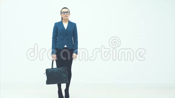 年轻的商务小姐站在白色的背景上手里拿着一个黑色的袋子往镜头里看从一个视频的预览图