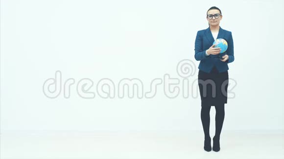 年轻的商业女性站在白色的背景上把地球抱在怀里高兴起来在舞会上慢慢视频的预览图