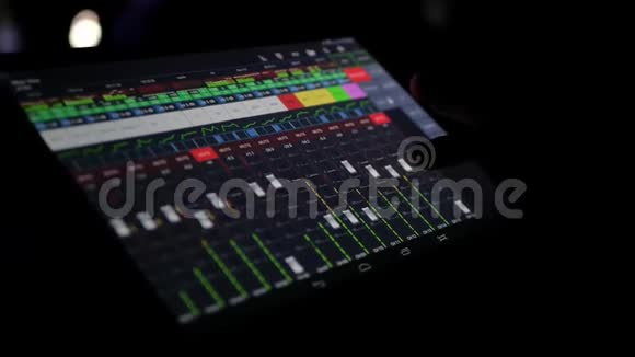音响工程师利用大型平板电脑上的程序在音乐会上远程调节声音控制滑块视频的预览图