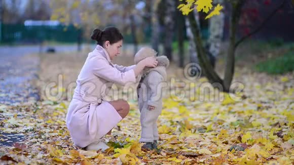秋天的傍晚母亲小心翼翼地把衣服系在街上送给她的女儿视频的预览图