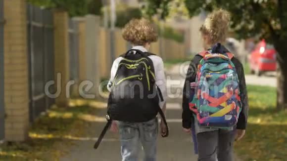 两个女孩和男孩在城市街道上走过汽车妹妹和她的哥哥回学校太阳在后台视频的预览图