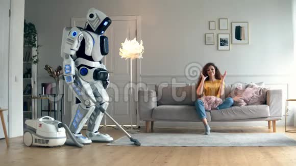 这位女士正在沙发上放松而机器人却在徘徊视频的预览图