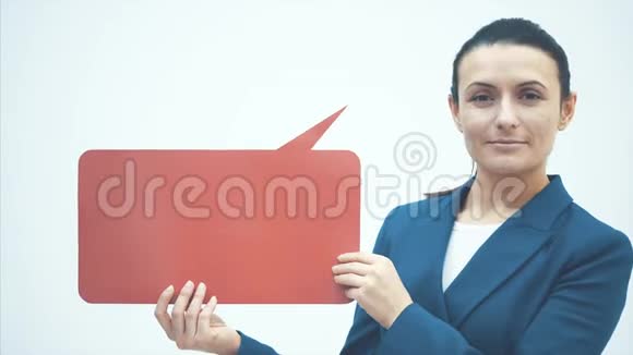 年轻的老师站在白色的背景上用两只手握住红色的语音泡泡快关门视频的预览图