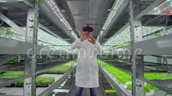 科学家一个穿着白色实验服的人在农场里用玻璃虚拟现实来控制灌溉视频的预览图