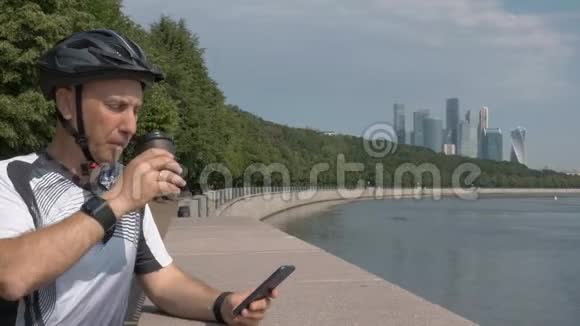 穿着运动服的人骑着自行车头盔在美丽的城市长廊上休息视频的预览图
