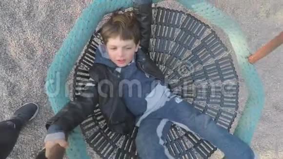 孩子躺在秋千上在照相机里抬起腿视频的预览图