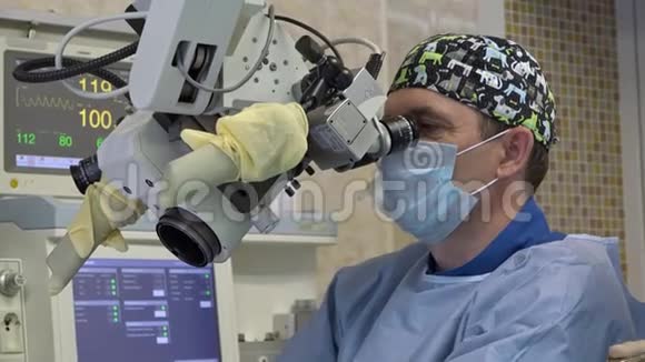 一名男性外科医生用外科显微镜对病人耳鼻喉科器官进行显微手术创新视频的预览图