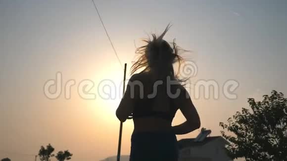 活跃的女孩沿着乡村道路慢跑背景是日落年轻的运动女性晚上在户外工作视频的预览图
