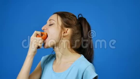 健康牙齿的微笑女人在工作室蓝底吃红苹果减肥理念素食视频的预览图
