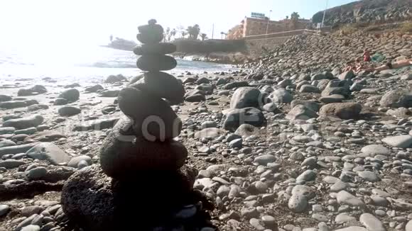 4kdolly海洋海滩上的鹅卵石和日落光线制作的塔的视频视频的预览图