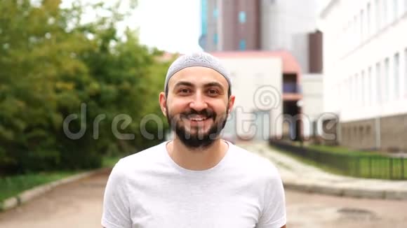 城里英俊快乐的长胡子穆斯林男人笑了视频的预览图
