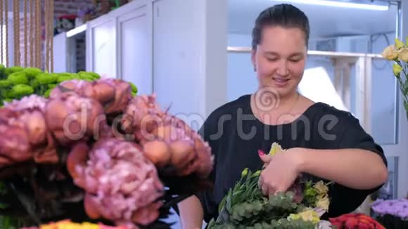花商妇女做大花束并与客户在花店交谈视频的预览图