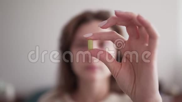 一个女人手中的药片女孩看着手里的药药物剂量显示药丸视频的预览图